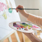 A person participates in art therapy, a form of creative addiction treatment.