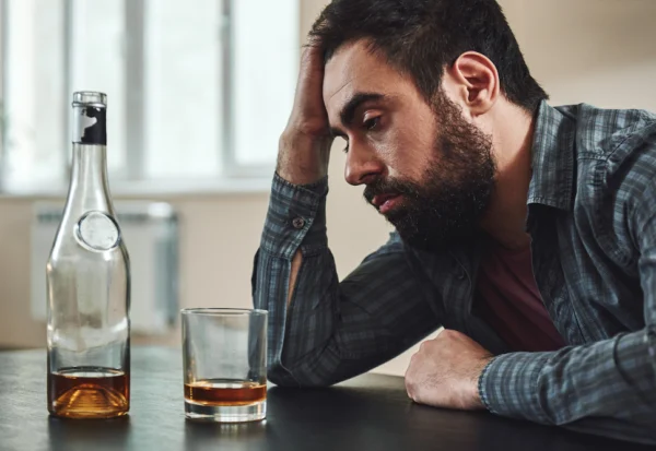 A man drinks an alcoholic beverage.